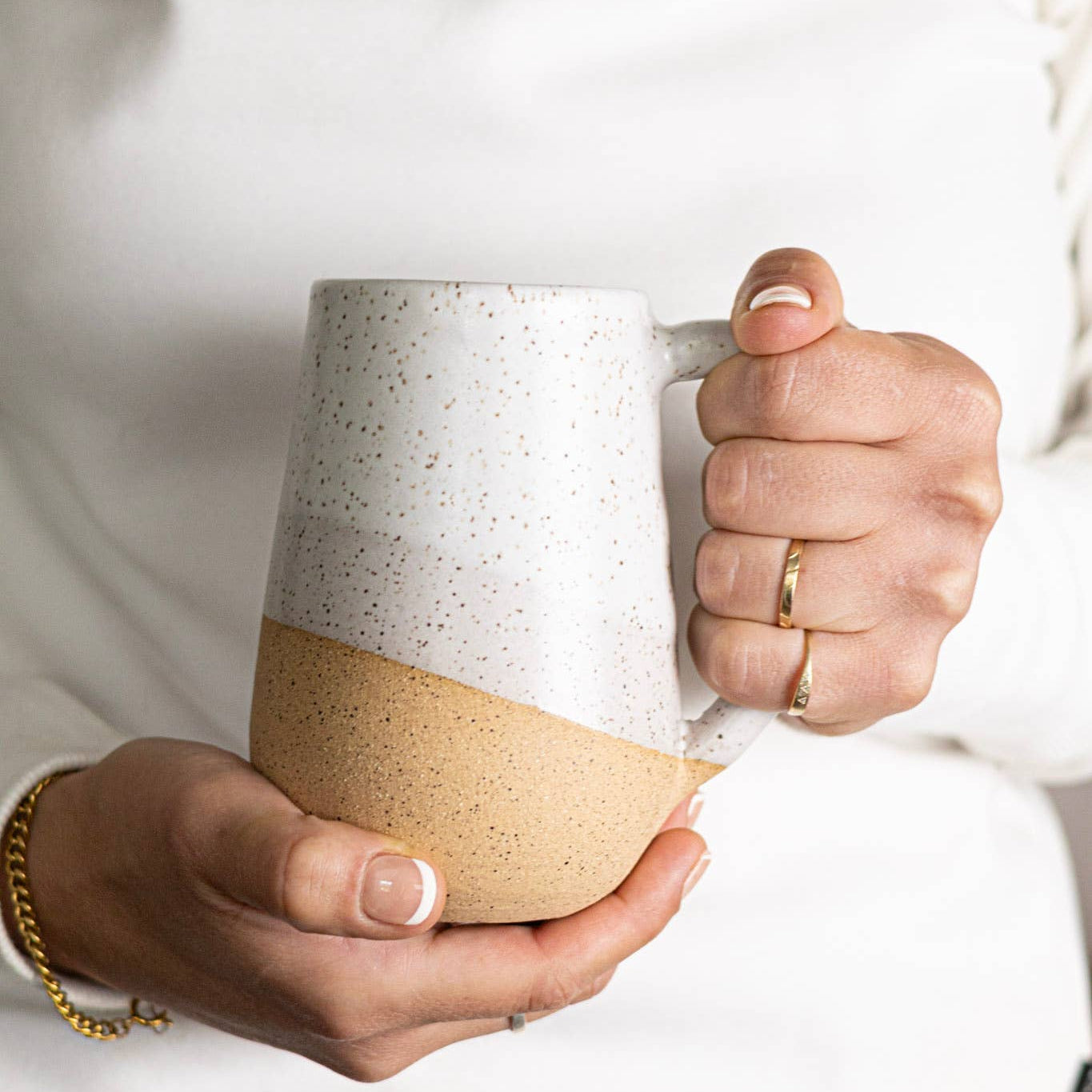 Person holding a ceramic mug with two-tone design