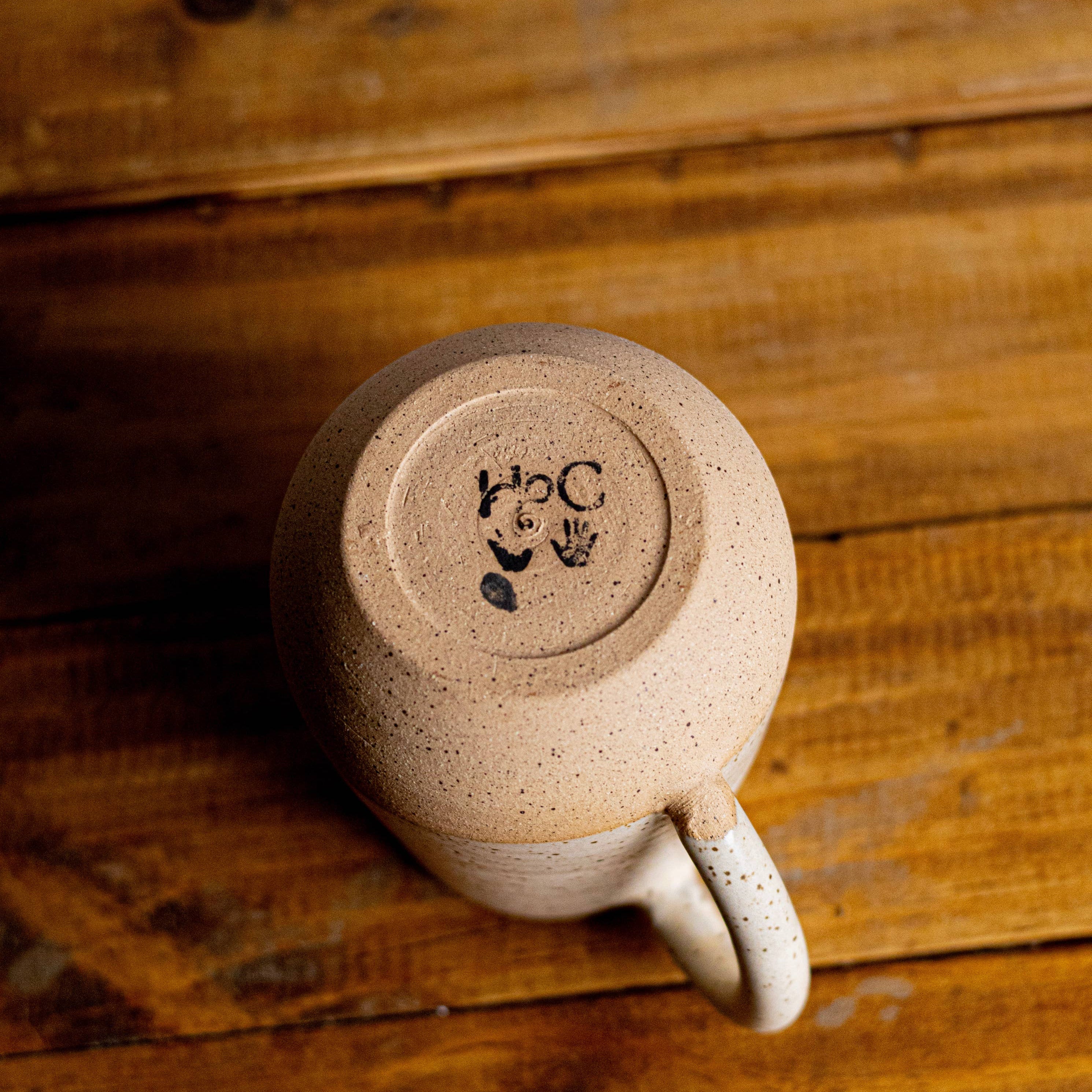 Ceramic mug with a logo on a wooden surface
