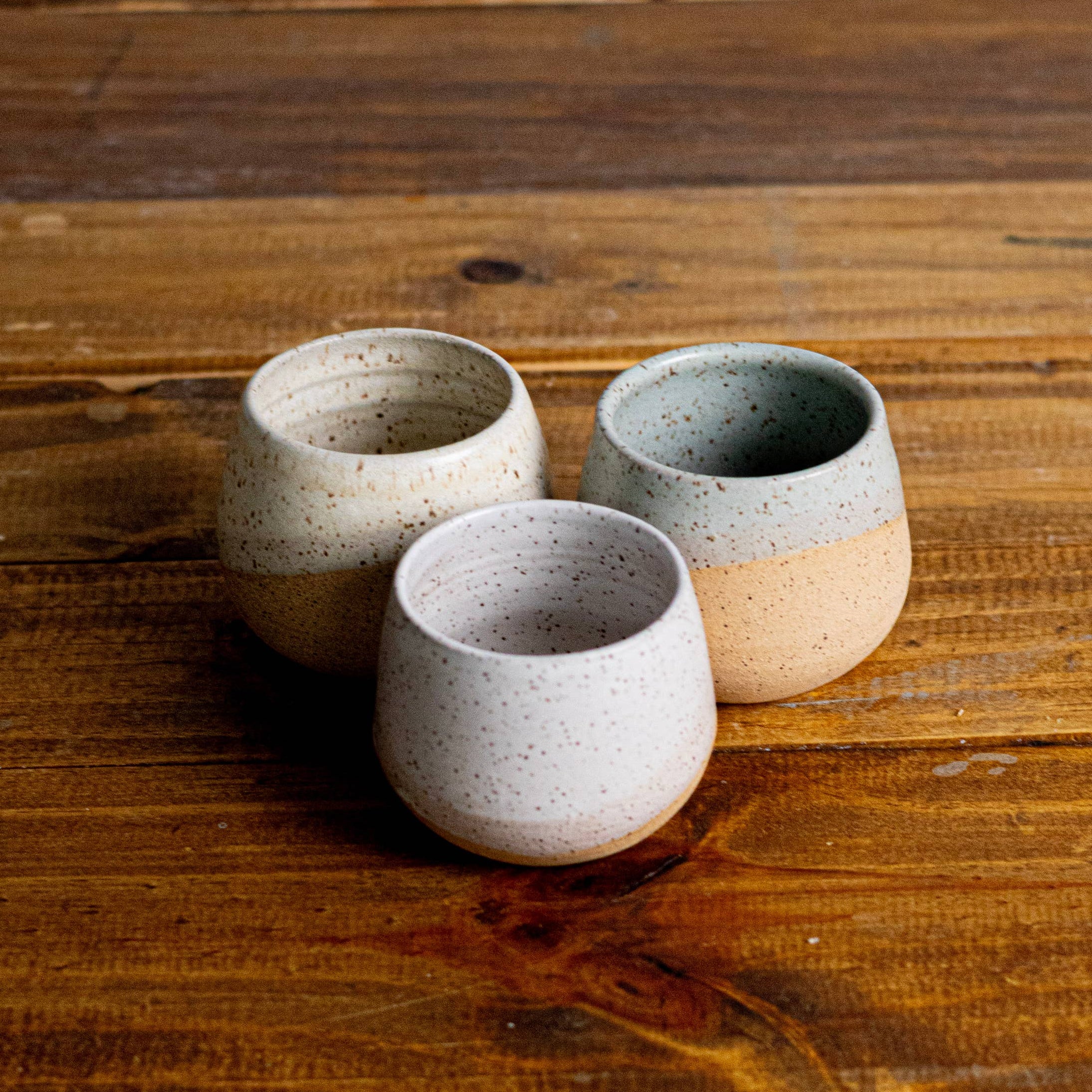 Three ceramic cups on a wooden surface