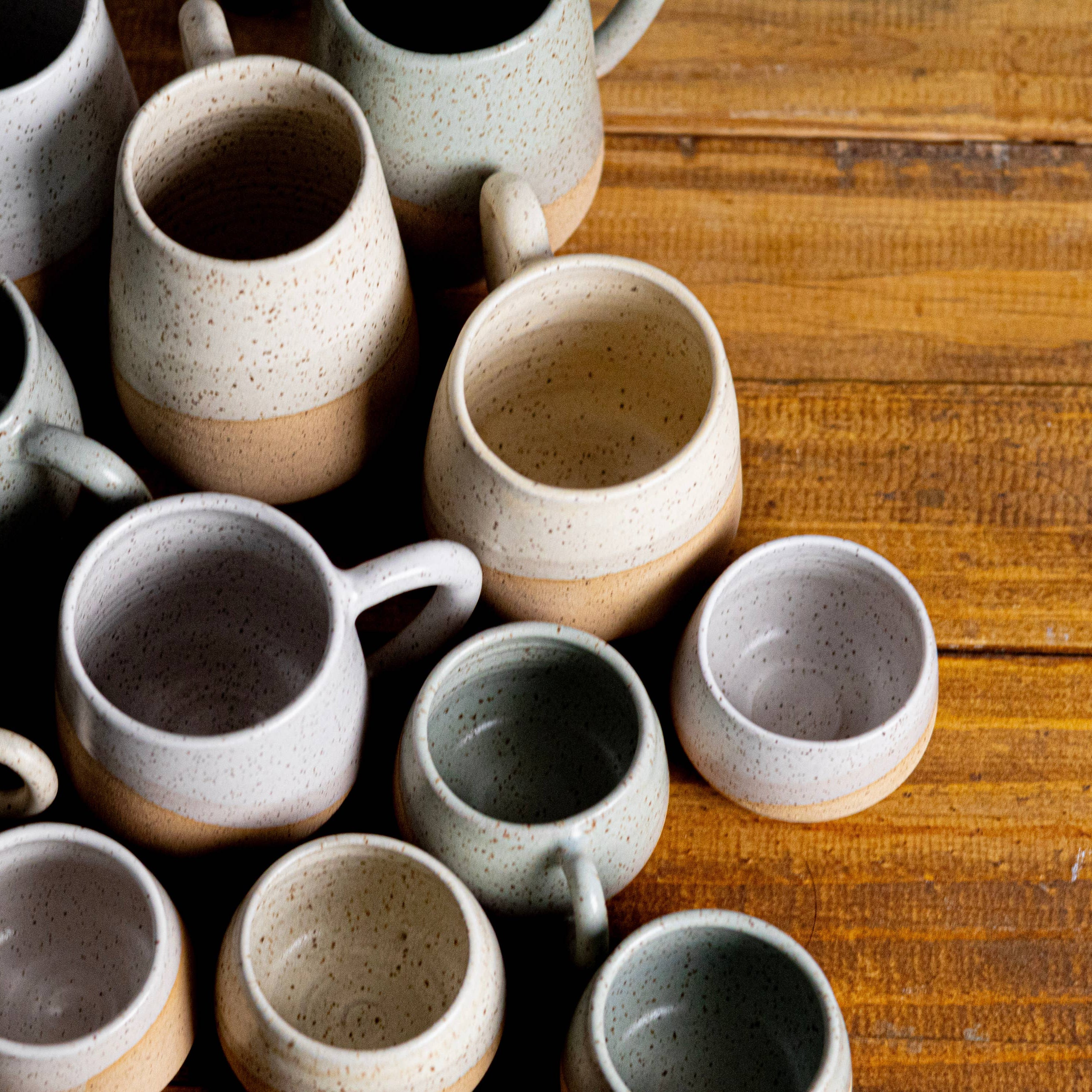 Collection of ceramic mugs on a wooden surface