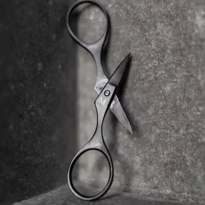 Pair of scissors on a textured surface