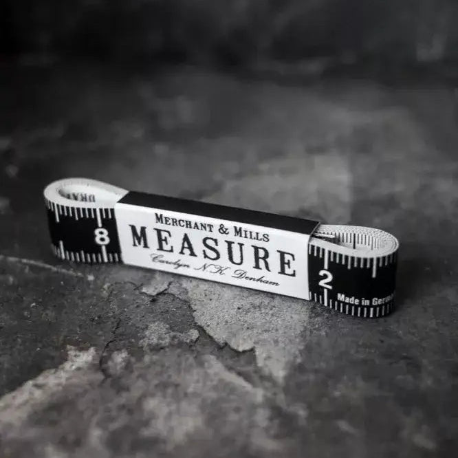 Measuring tape with 'Measure' text on a textured surface