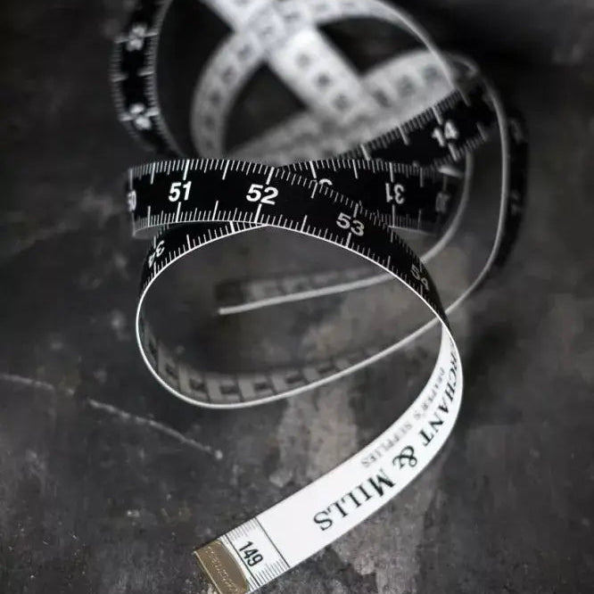 Measuring tape coiled on a dark surface