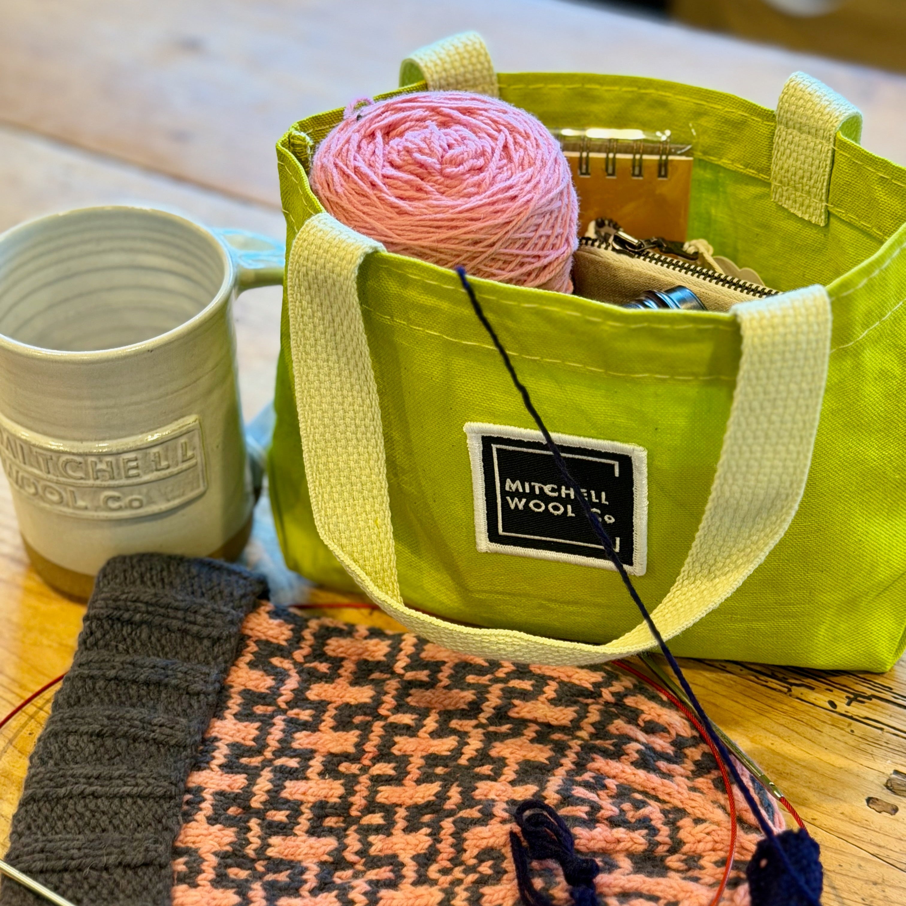 CITRON Green bag with yarn and knitting supplies on a wooden surface
