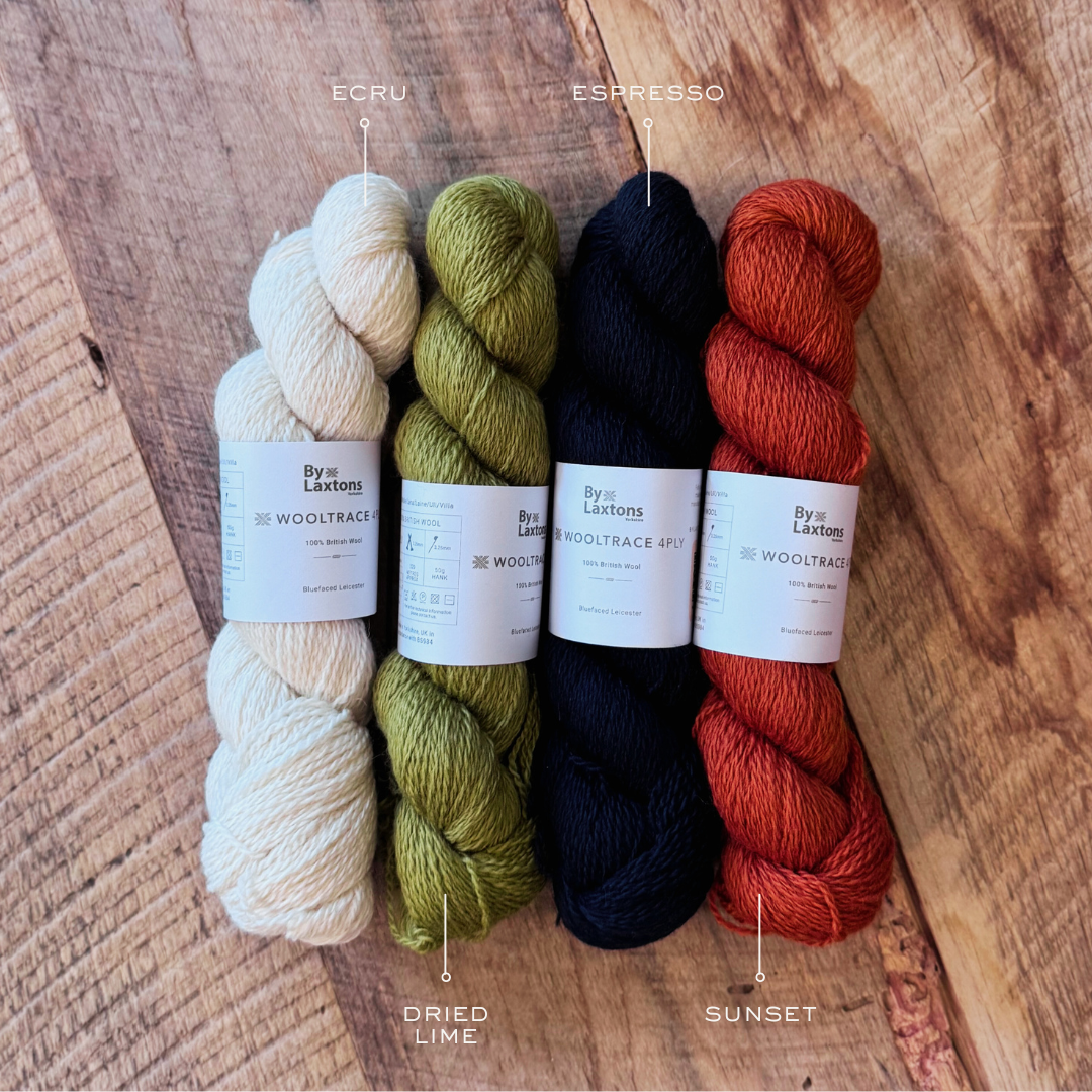 MID CENTURY COLLECTION - Four skeins of yarn in different colors on a wooden surface