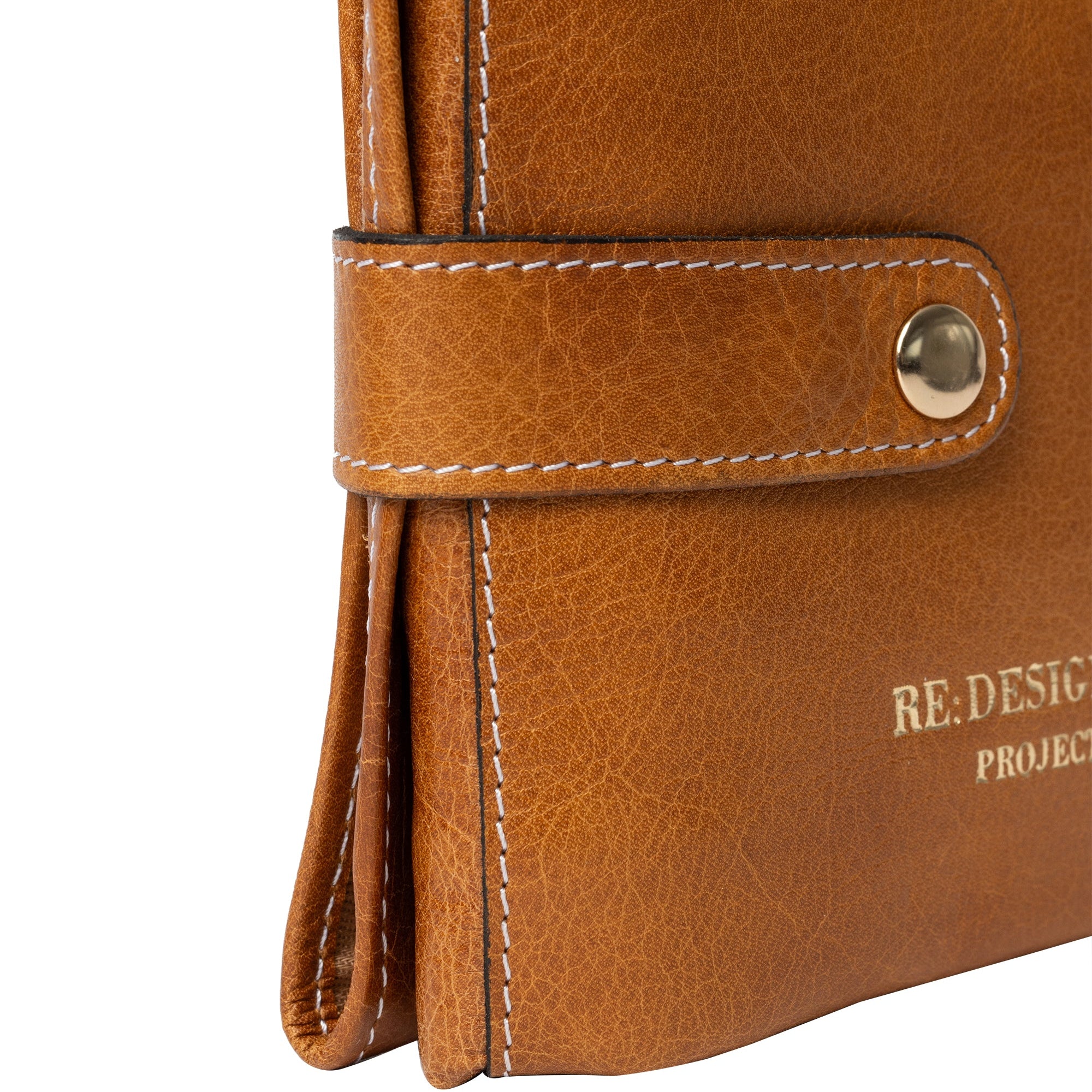 Close-up of a brown leather notebook with visible branding on a white background