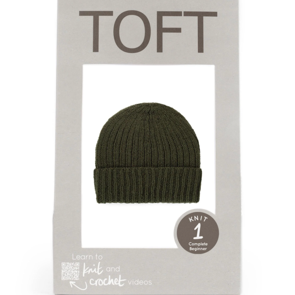 Green knit beanie in TOFT packaging on a white background