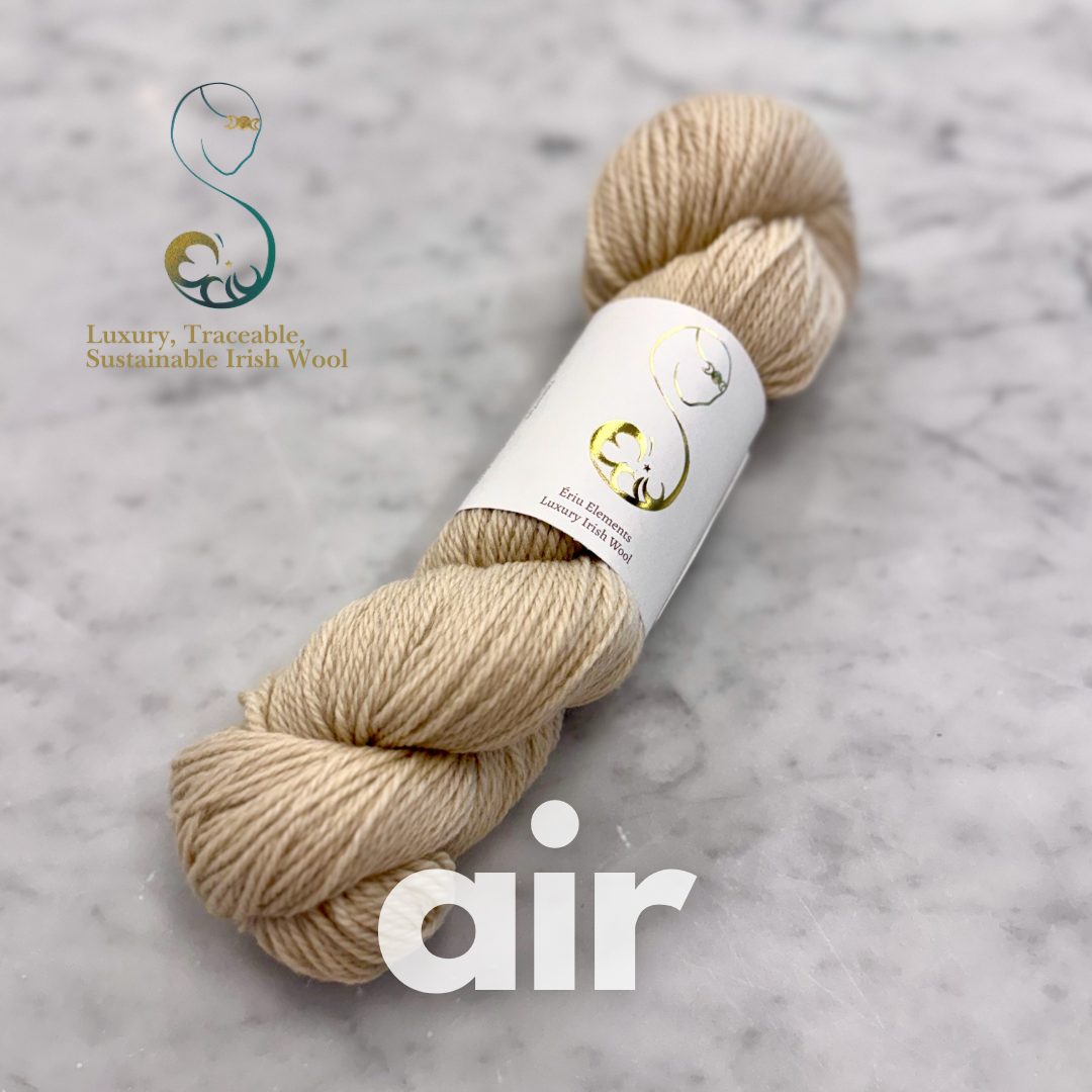 Beige skein of Irish yarn with a label on a gray marble background