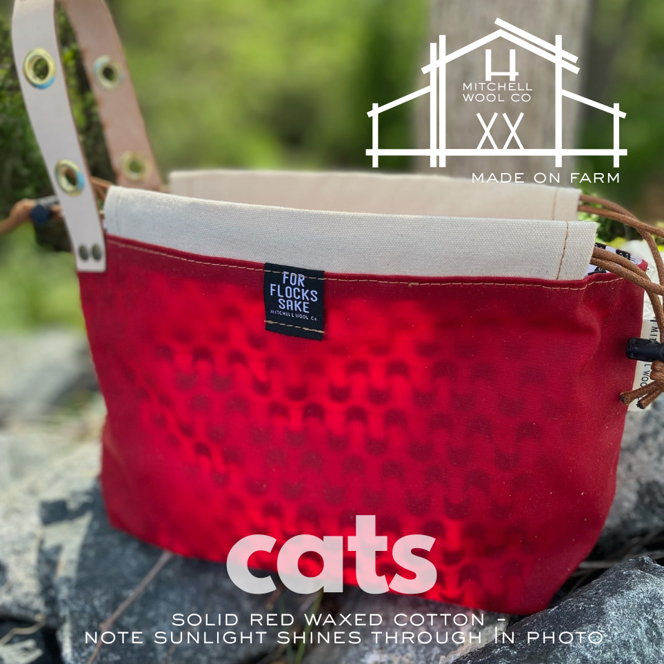 Red waxed cotton bag with a label on a natural background, featuring the Mitchell Wool Co logo.