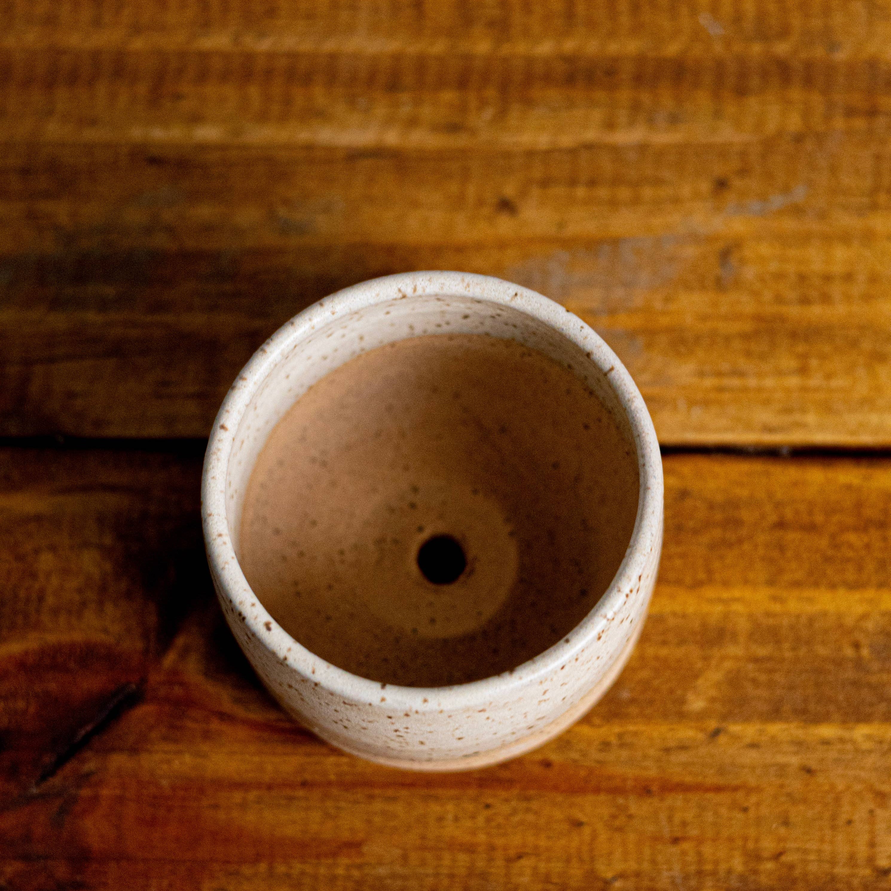 Small ceramic pot on a wooden surface