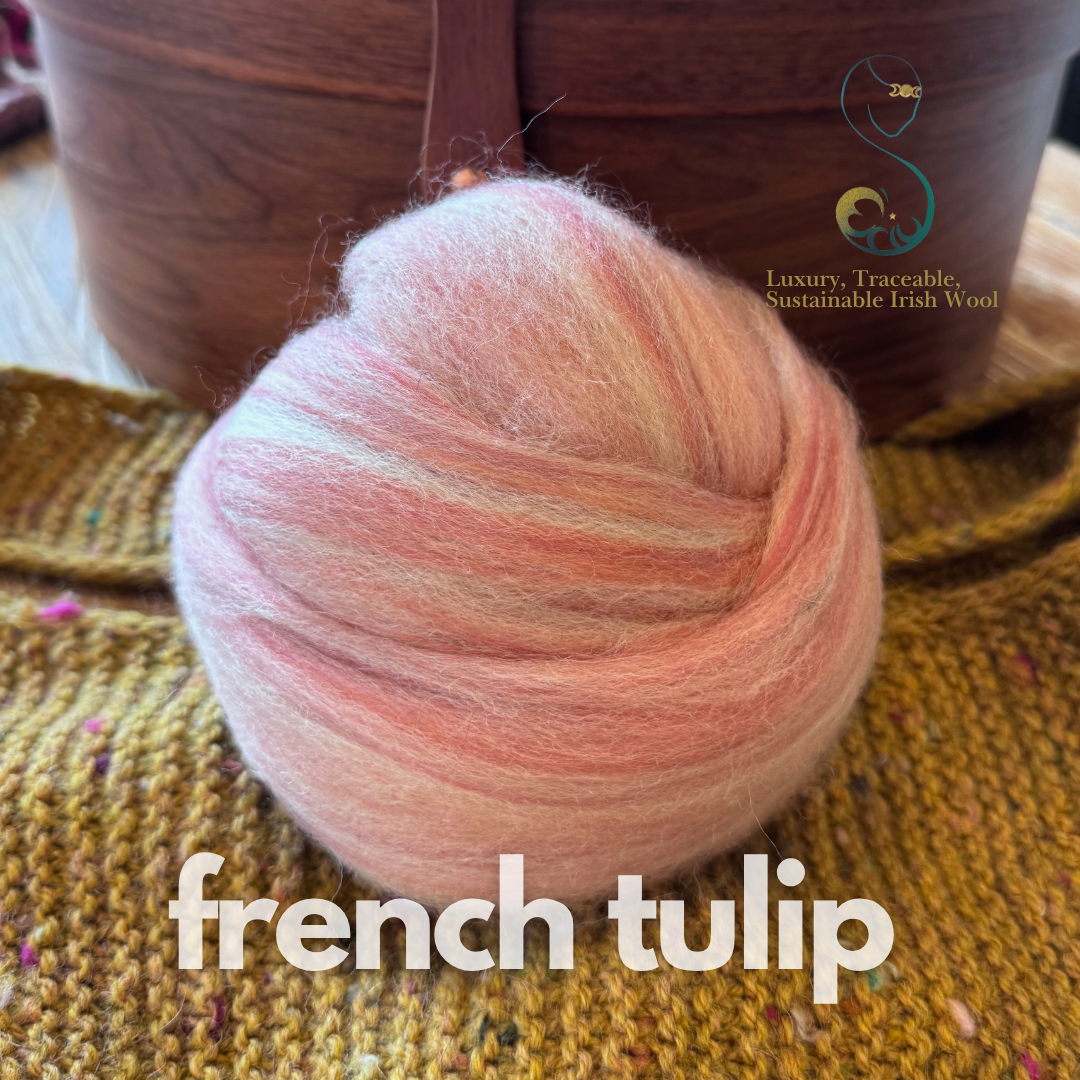 petal pink dollup of combed top from BFL Irish sheep labeled 'French Tulip' on a textured surface with a brand logo in the background.