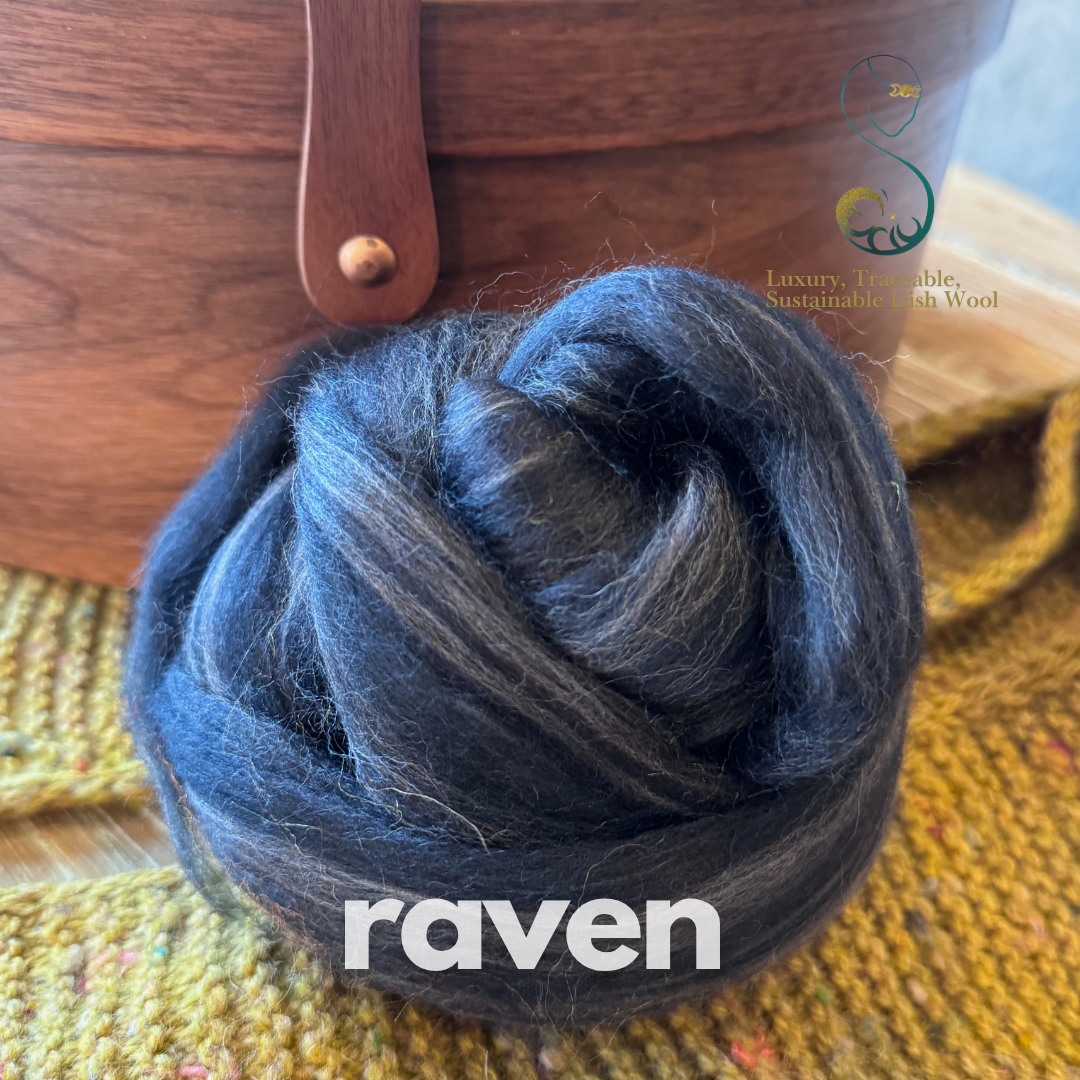 Inky blue dollup of combed top from BFL Irish sheep with 'raven' branding on a textured surface
