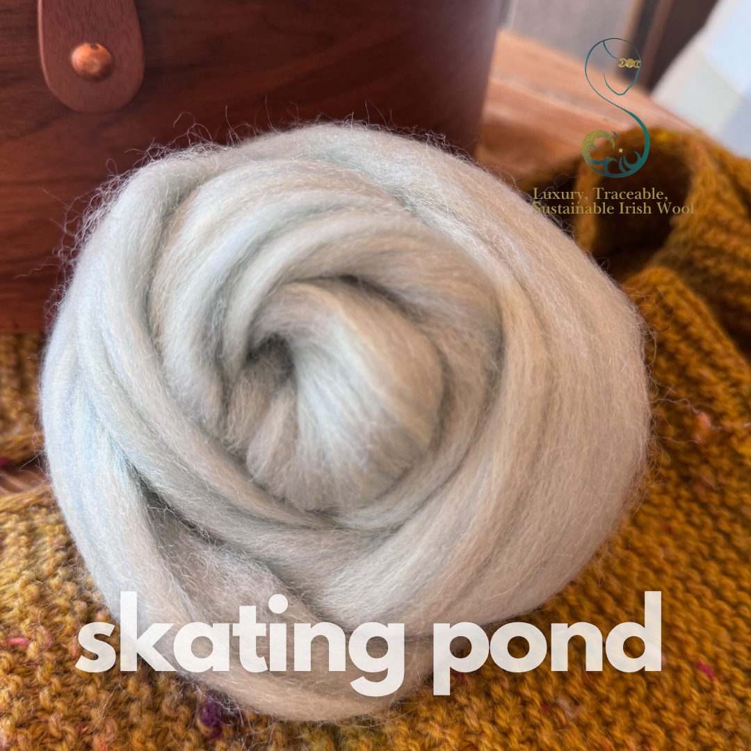 Icy light blue dollup of combed top from BFL Irish sheep on a textured surface with 'skating pond' branding.