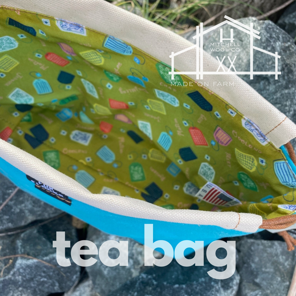 Tea bag with colorful pattern on a textured surface, featuring 'Mitchell Woods Co.' branding.